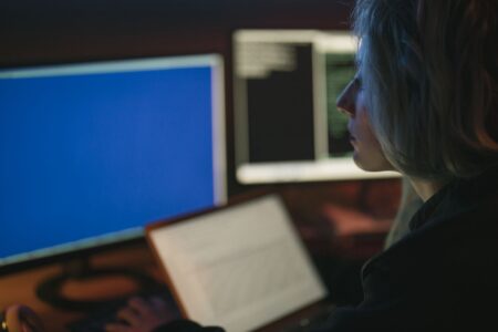 Analyste travaillant de nuit devant plusieurs écrans