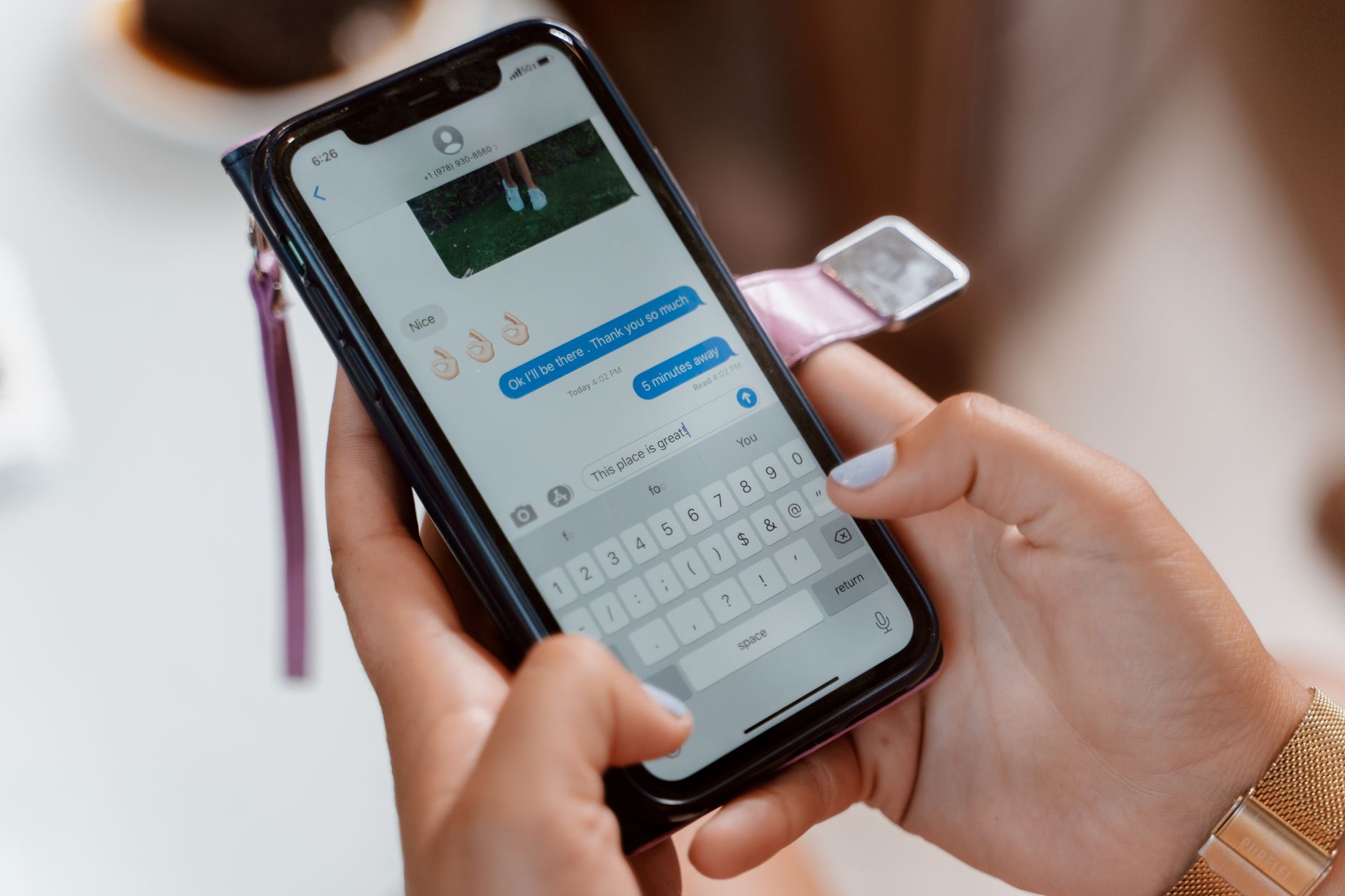 Femme tapant sur un smartphone, envoyant un message texte avec un emoji.